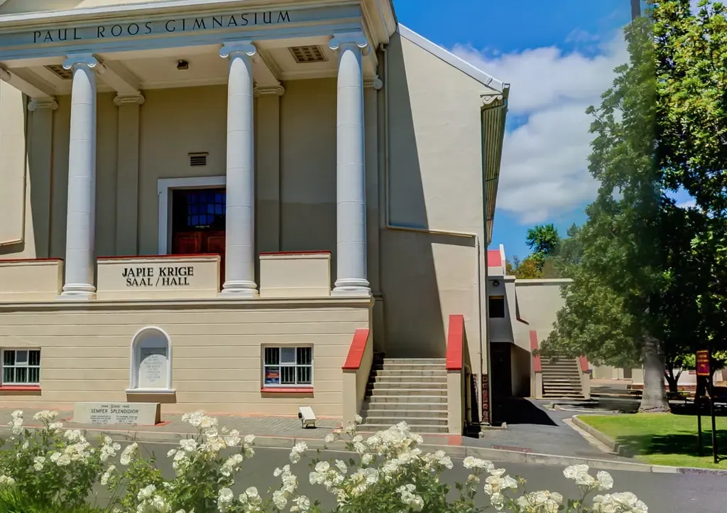 The right-hand side of the Japie Krige Hall, showing two staircases: one tucked against the hall wall, and a second one further along past the corner.